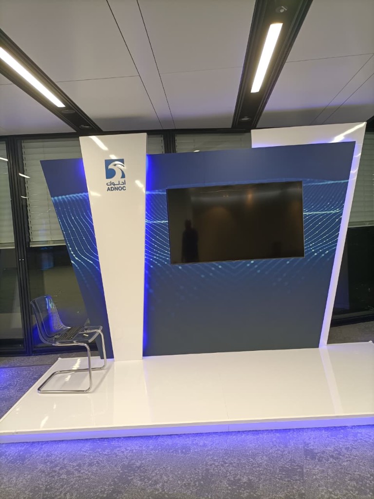 ADNOC exhibition booth with LED platform and acrylic chair