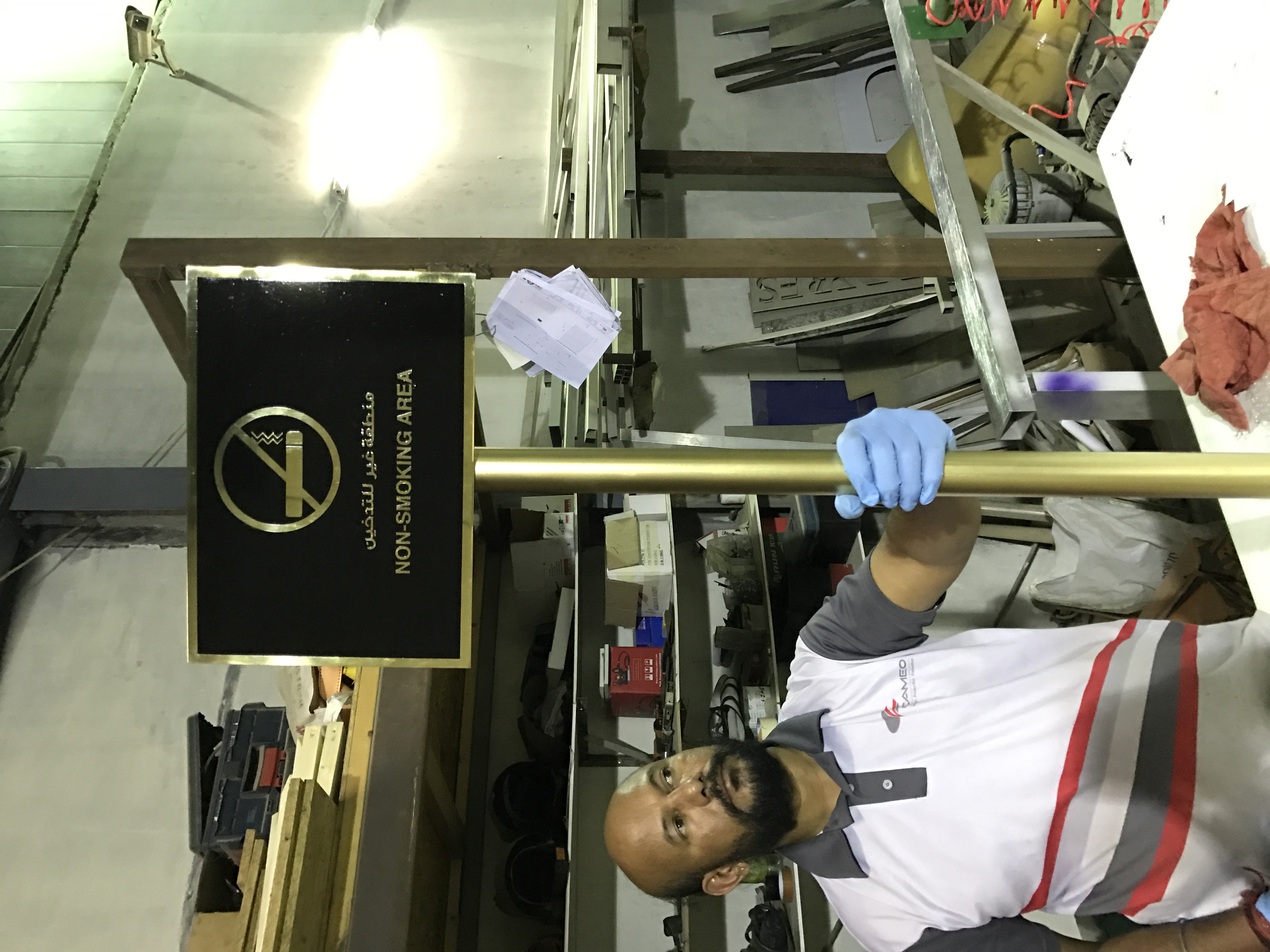 Black directional hanging sign being installed on site