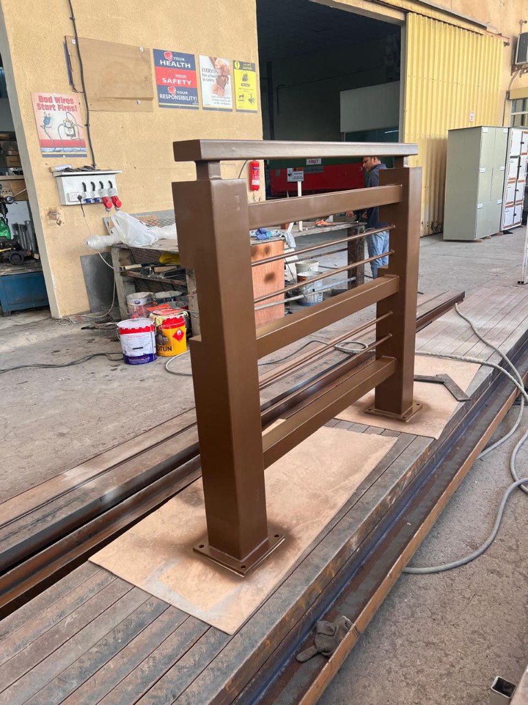 Heavy-duty brown metal railing with mounting base plates