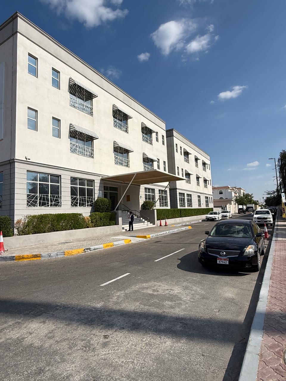Road view of building facade signage on white exterior