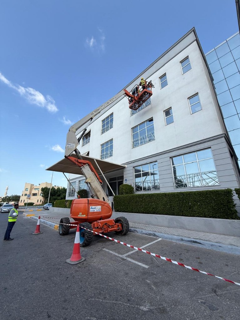 Signage installation on a commercial building using a cherry picker