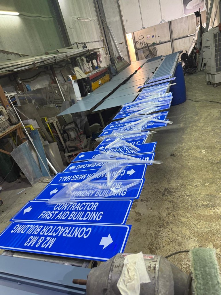 Batch of blue contractor camp directional signs in production