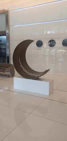 Crescent moon sculpture installed in a modern corporate lobby