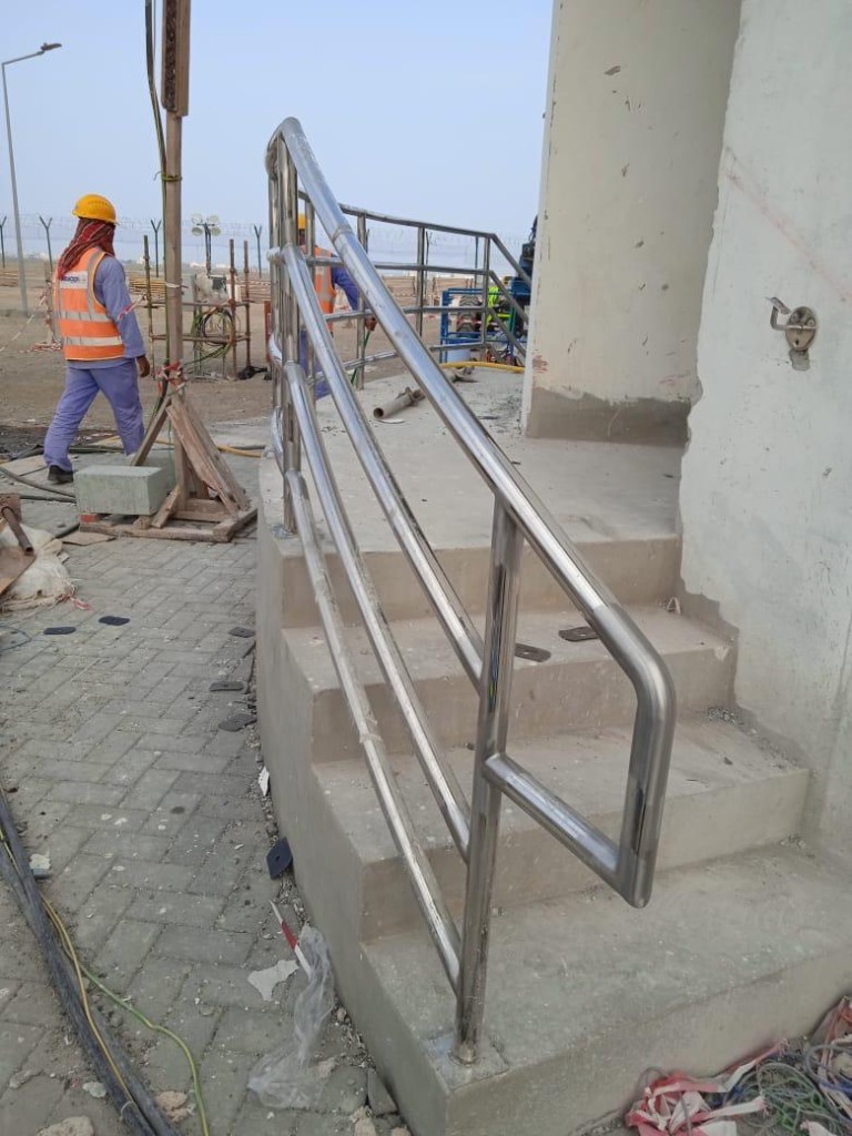 Curved stainless steel handrail installed at construction site