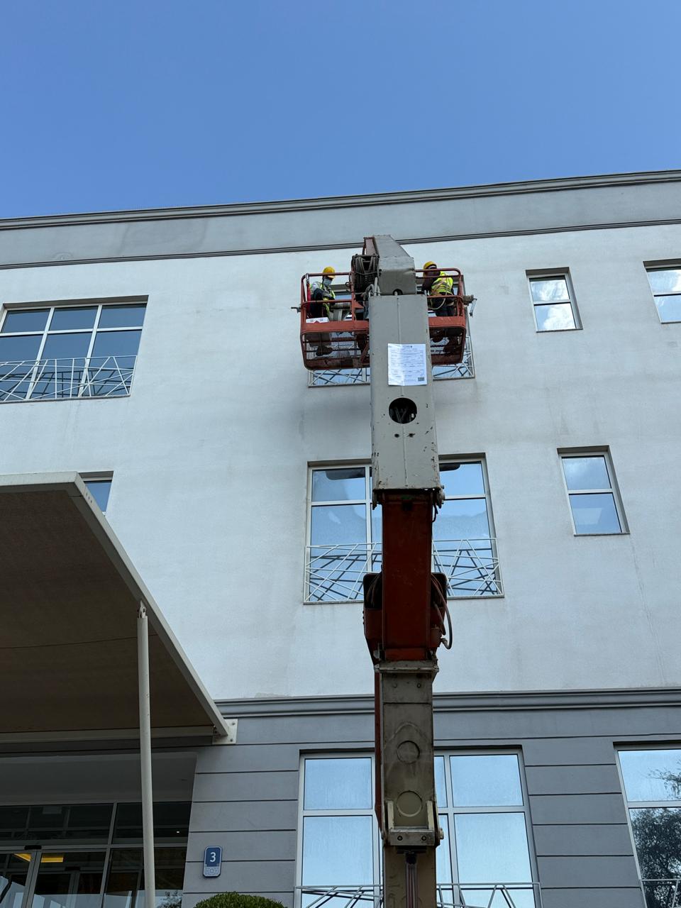Facade sign service lift positioned against a building