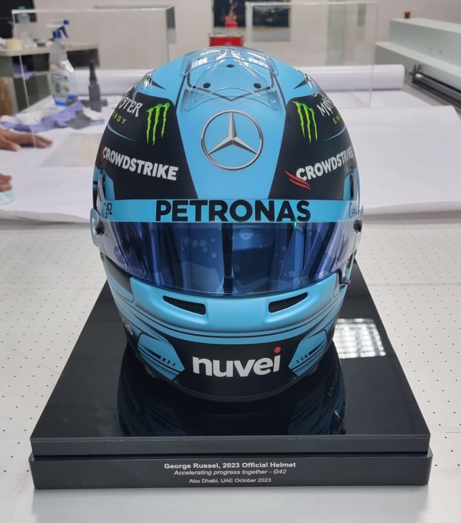 Front view of George Russell helmet on acrylic display stand