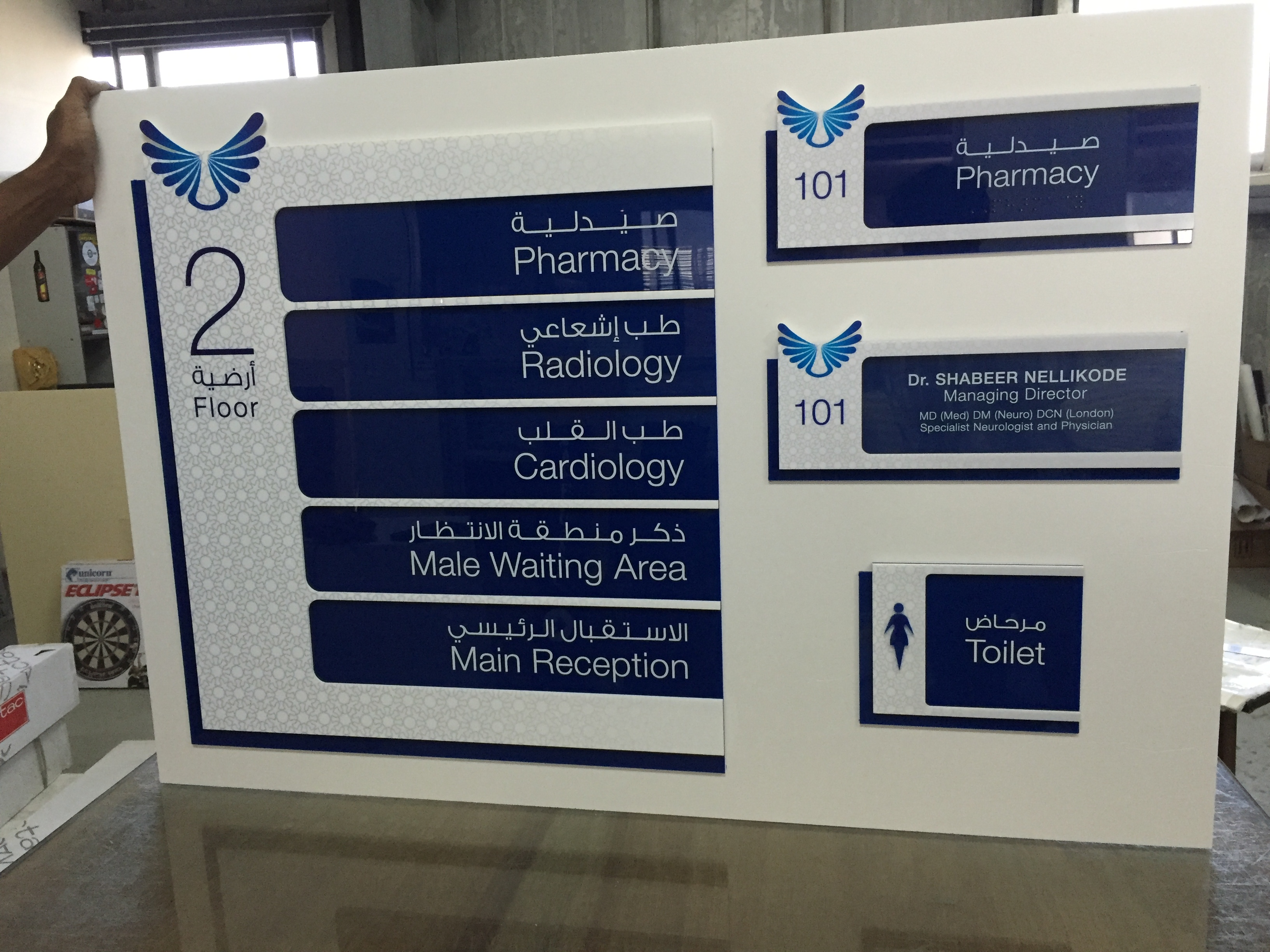 Hospital department directory sign with bilingual room numbers