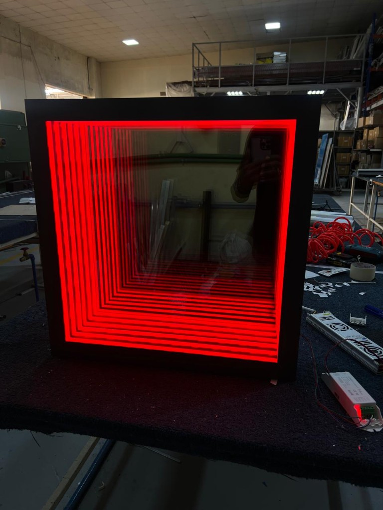 Square infinity mirror with red LED lighting in workshop