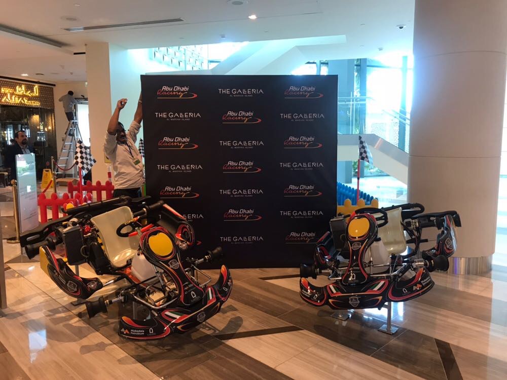 Mall directory and event signage beside display cars