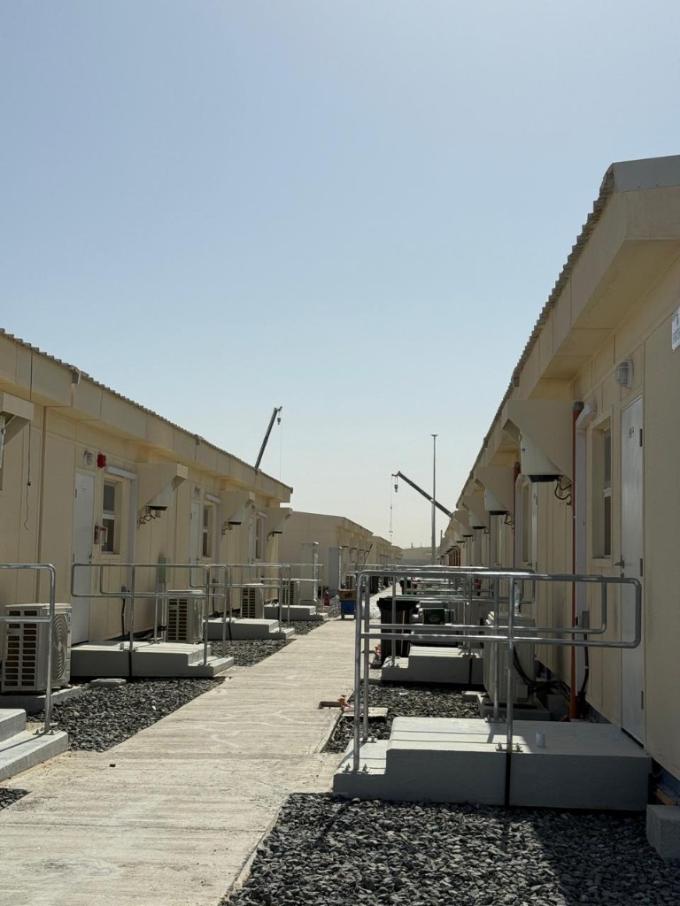 Rows of prefabricated modular cabins along a site corridor