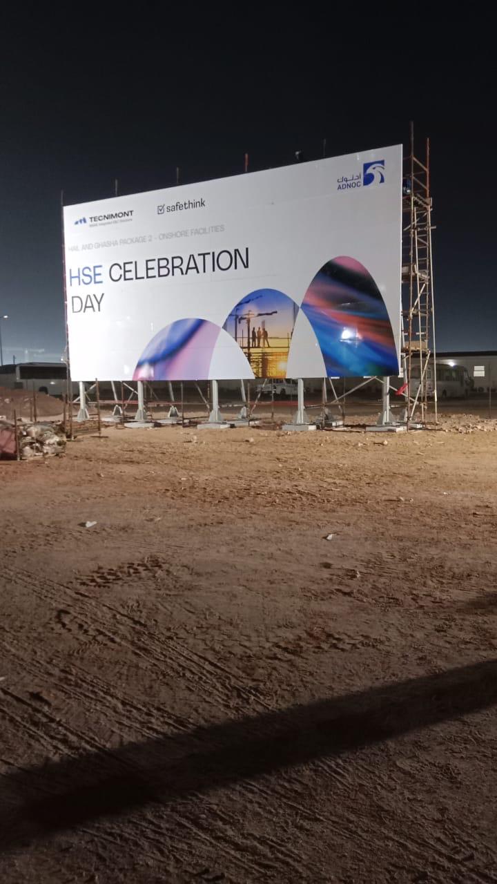 Large illuminated construction billboard at night