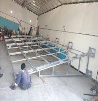 Dark grey perforated metal folding gate in industrial corridor