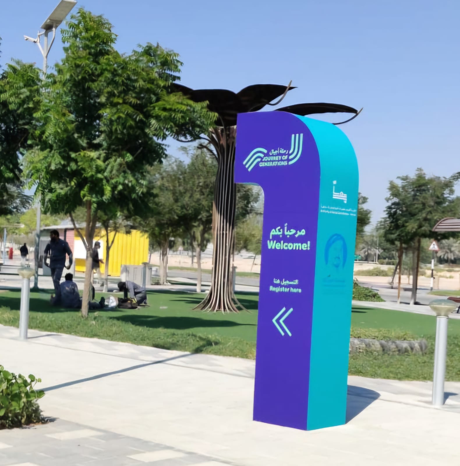 Purple public-space directional totem in landscaped walkway