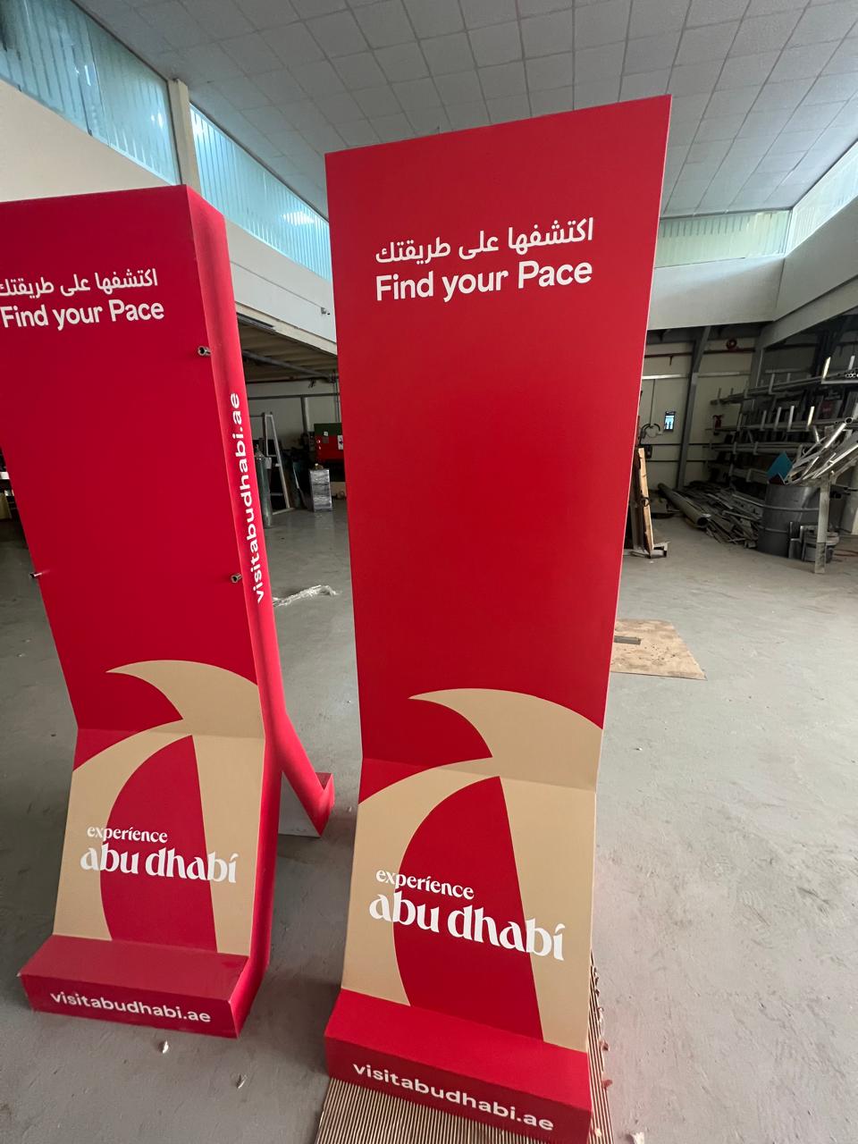 Red Abu Dhabi event totem signs in parking area