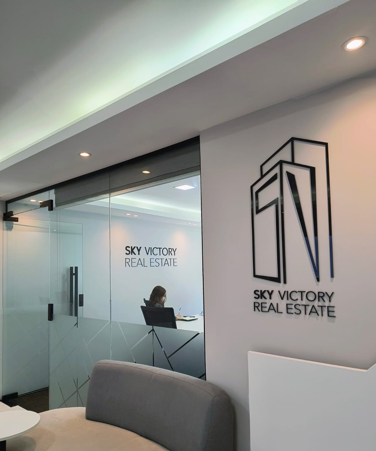 Sky Victory Real Estate reception signage on white wall