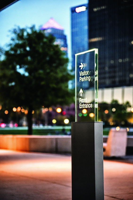 Slim parking wayfinding pylon in landscaped exterior