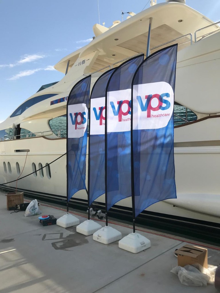 VPS Healthcare branded feather flags on marina dock