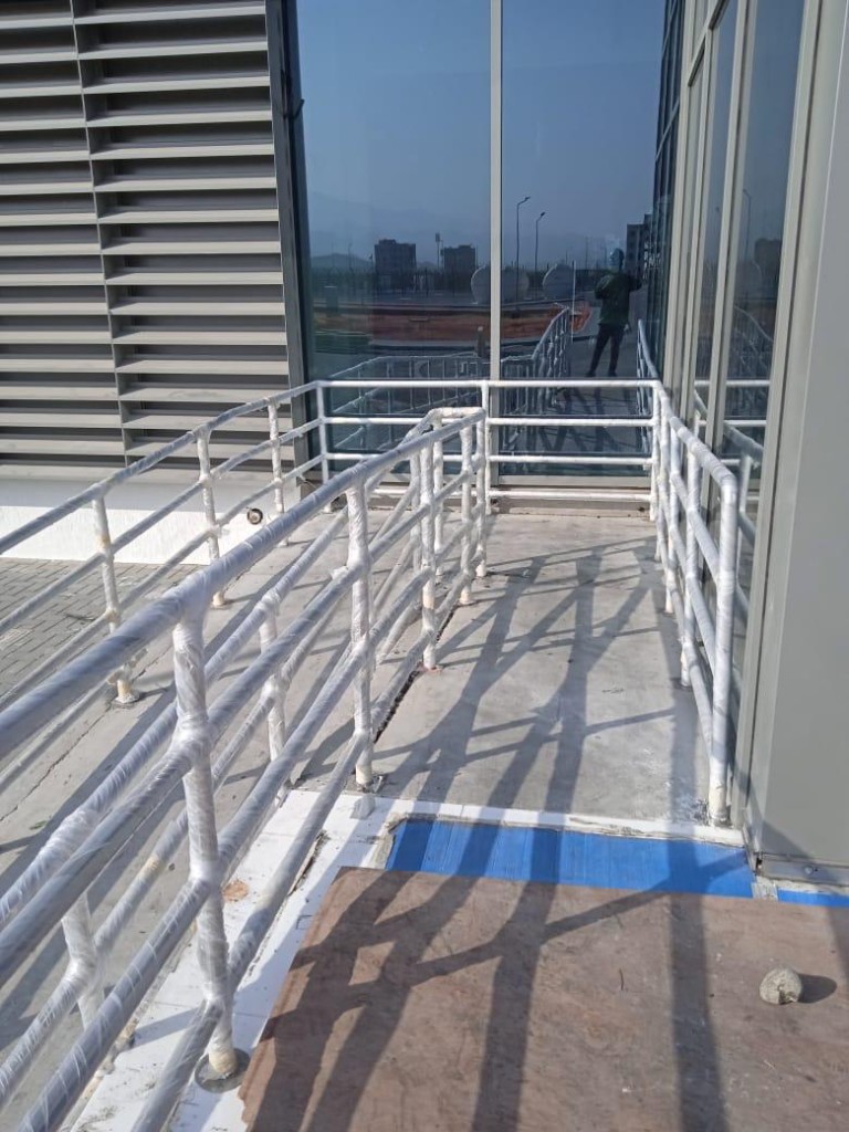 Newly installed white metal handrail wrapped in protective film
