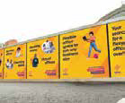 Yellow construction hoarding graphics along a site boundary